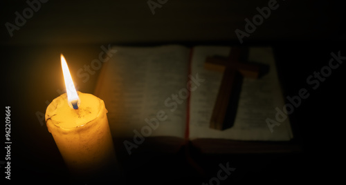 Candle with the Bible on wooden table in the night. worship prayer and bible study concept.