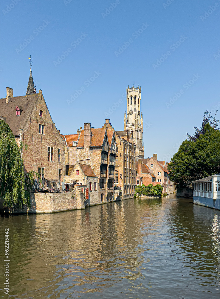 Fototapeta premium Brugge, Flanders, Belgium - June 25, 2024: Halletoren seen from Rozenhoedkaai and Dijver canal,