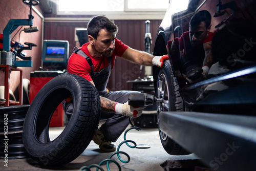 Wheel repairman using tool to remove damaged tire from the car.