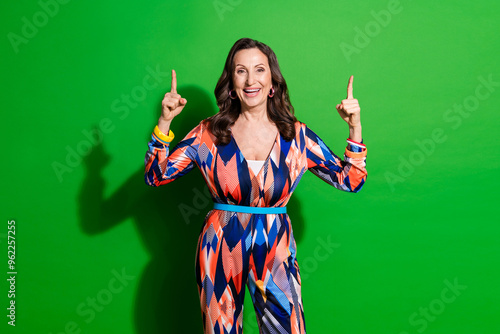 Photo of cheerful pretty lady dressed print outfiit showing two fingers up empty space isolated green color background photo