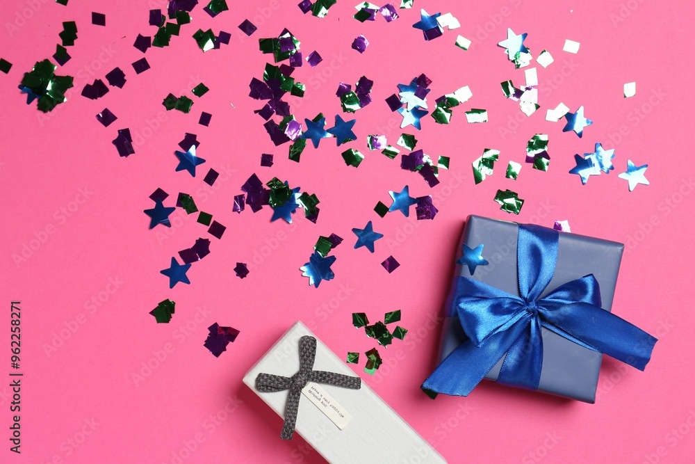 Shiny confetti and gift boxes on bright pink background, flat lay Shiny confetti and gift boxes on bright pink background, flat lay