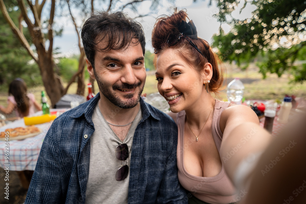 Happy Couple Taking Selfie at Outdoor Picnic, Smiling Friends Enjoying Nature Party Happy Couple Taking Selfie at Outdoor Picnic, Smiling Friends Enjoying Nature Party