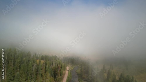 Aerial through low clouds in Madison Range in Montana in summer in early morning photo