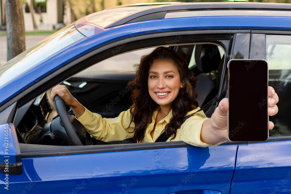 Happy European woman showing blank smartphone screen while sitting inside of her new auto, demonstrating copy space for mobile advertisement, mockup Happy European woman showing blank smartphone screen while sitting inside of her new auto, demonstrating copy space for mobile advertisement, mockup