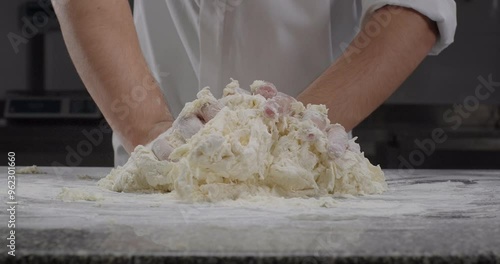 Male chef knead dough with hands. Traditional Italian pasta recipe. Close-up