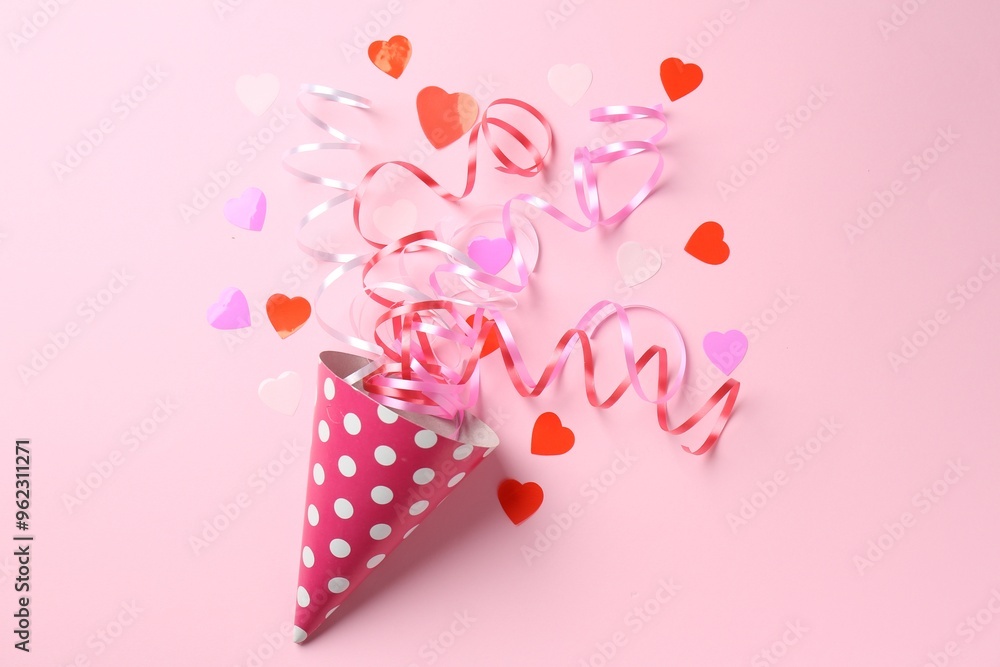 Party hat with confetti and streamers on pink background, flat lay Party hat with confetti and streamers on pink background, flat lay