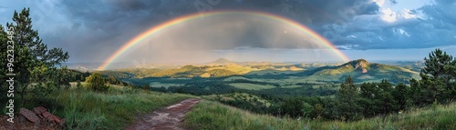 Bright rainbow over a rural landscape after a rainstorm, colorful weather, hope and renewal