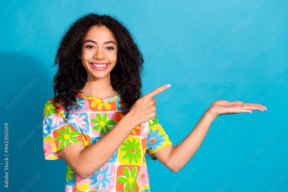 Photo of shiny attractive lady dressed flower print t-shirt pointing finger showing arm empty space isolated blue color background