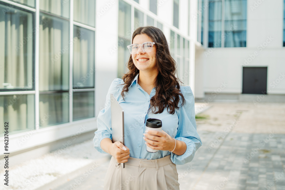 Fototapeta premium Young successful woman is going to work at modern business building 