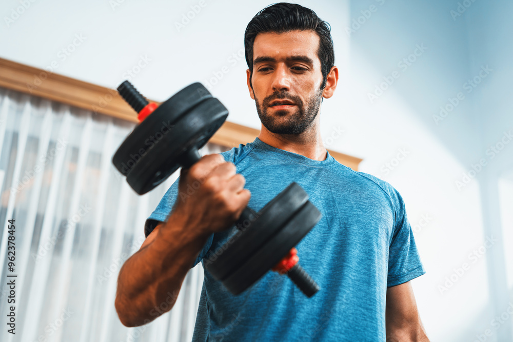 Athletic body and active sporty man lifting dumbbell weight for effective targeting muscle gain at gaiety home as concept of healthy fit body home workout lifestyle. Athletic body and active sporty man lifting dumbbell weight for effective targeting muscle gain at gaiety home as concept of healthy fit body home workout lifestyle.