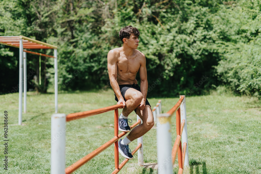 Fototapeta premium Fit and strong male sports person working out in the park doing outdoor exercises on a sunny day.
