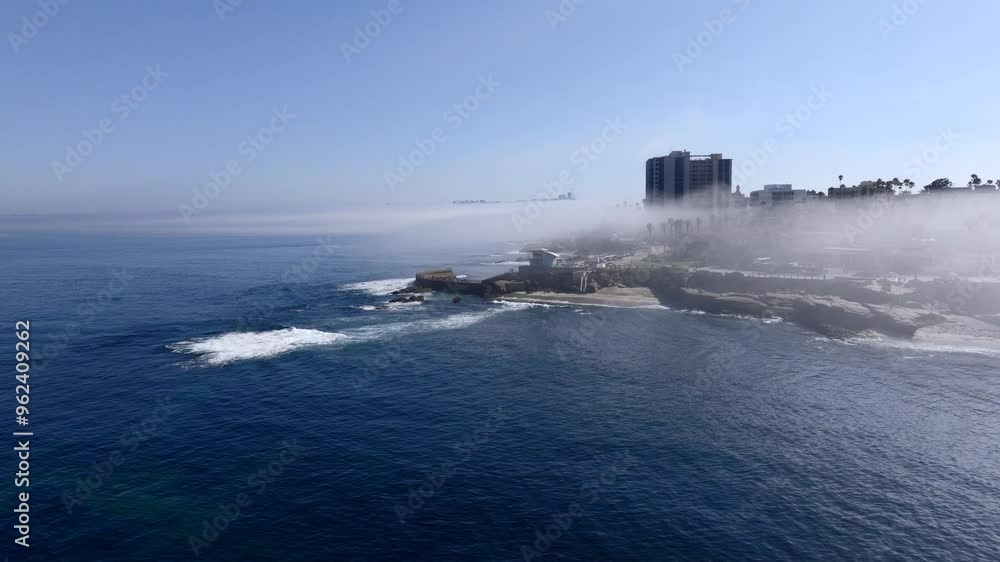 Aerial view of the La Jolla coast with a foggy marine layer billowing over the shore with views of the Pacific Ocean and scenic vies of La Jolla San Diego California Aerial view of the La Jolla coast with a foggy marine layer billowing over the shore with views of the Pacific Ocean and scenic vies of La Jolla San Diego California