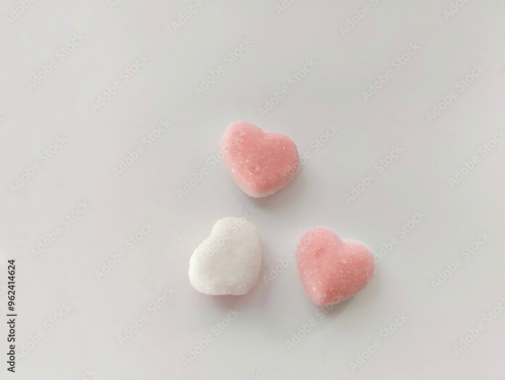 Obraz premium Pink love candy with a soft and chewy texture and sprinkled with sugar on top. on white backgrounds