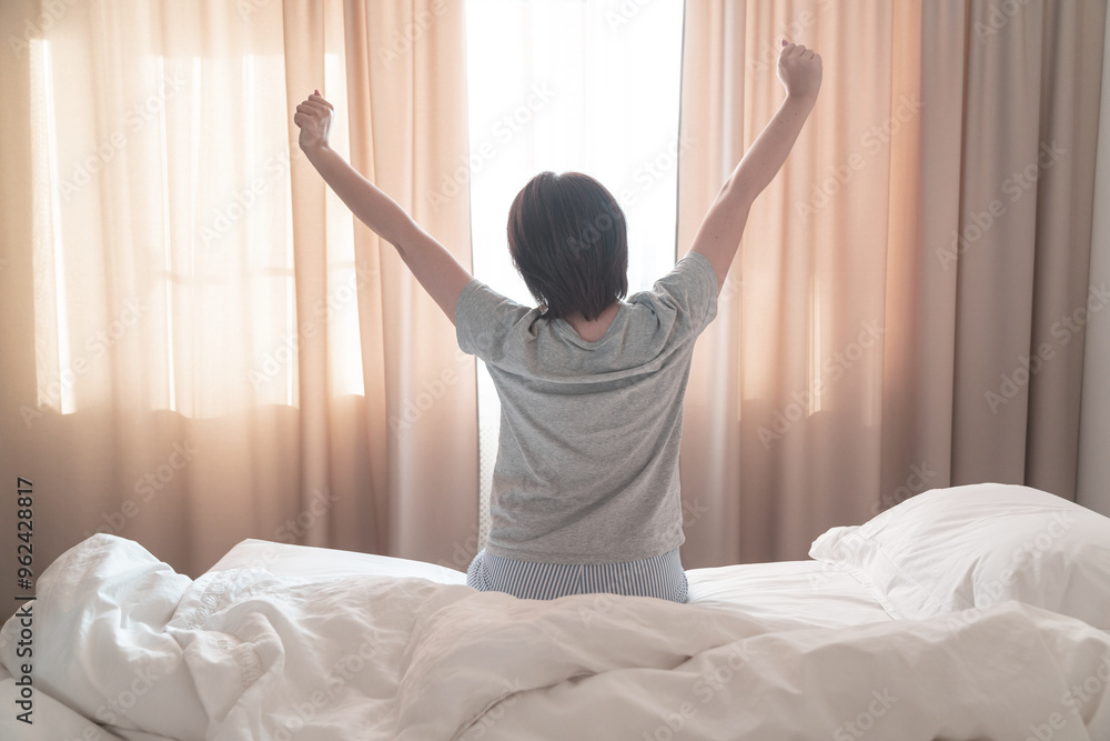 Woman stretching in bed after wake up, soft tone Woman stretching in bed after wake up, soft tone