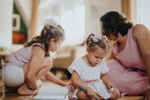 Mother and her daughters engaging in a creative drawing activity at home, fostering family bonding and creativity in a warm and cozy environment.