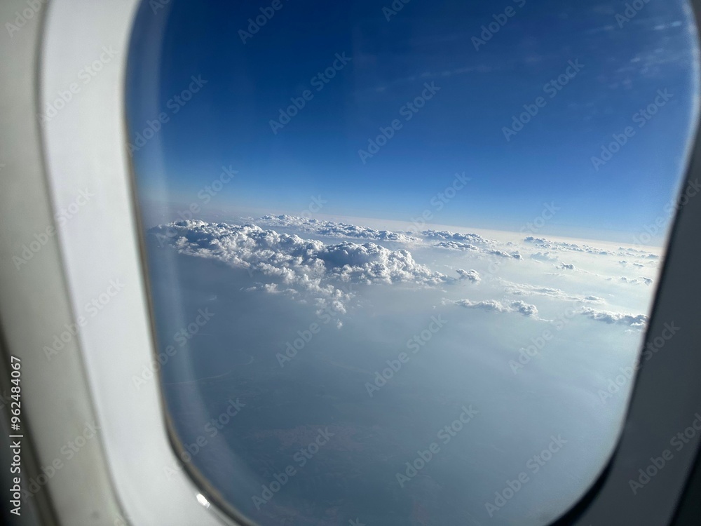 Beautiful blue sky with fluffy clouds, view from plane window Beautiful blue sky with fluffy clouds, view from plane window