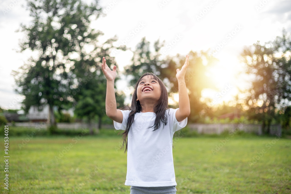 A young girl is standing in a grassy field A young girl is standing in a grassy field