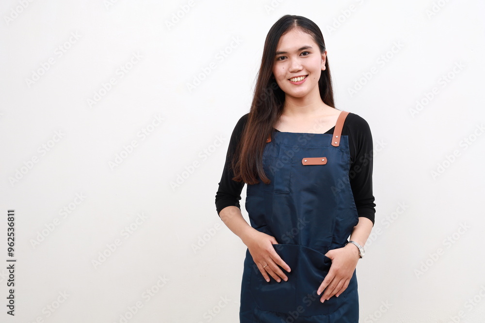 Happy asian barista woman in blue apron looking at camera. Coffee shop owner wearing cafe uniform and smiling, standing over white background Happy asian barista woman in blue apron looking at camera. Coffee shop owner wearing cafe uniform and smiling, standing over white background
