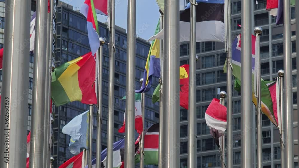 Flags from various countries blowing in the wind against a clear blue sky. Daytime footage showcasing international pride and unity through national symbols Flags from various countries blowing in the wind against a clear blue sky. Daytime footage showcasing international pride and unity through national symbols