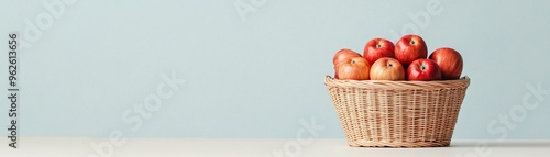 A basket of red apples against a light blue background.