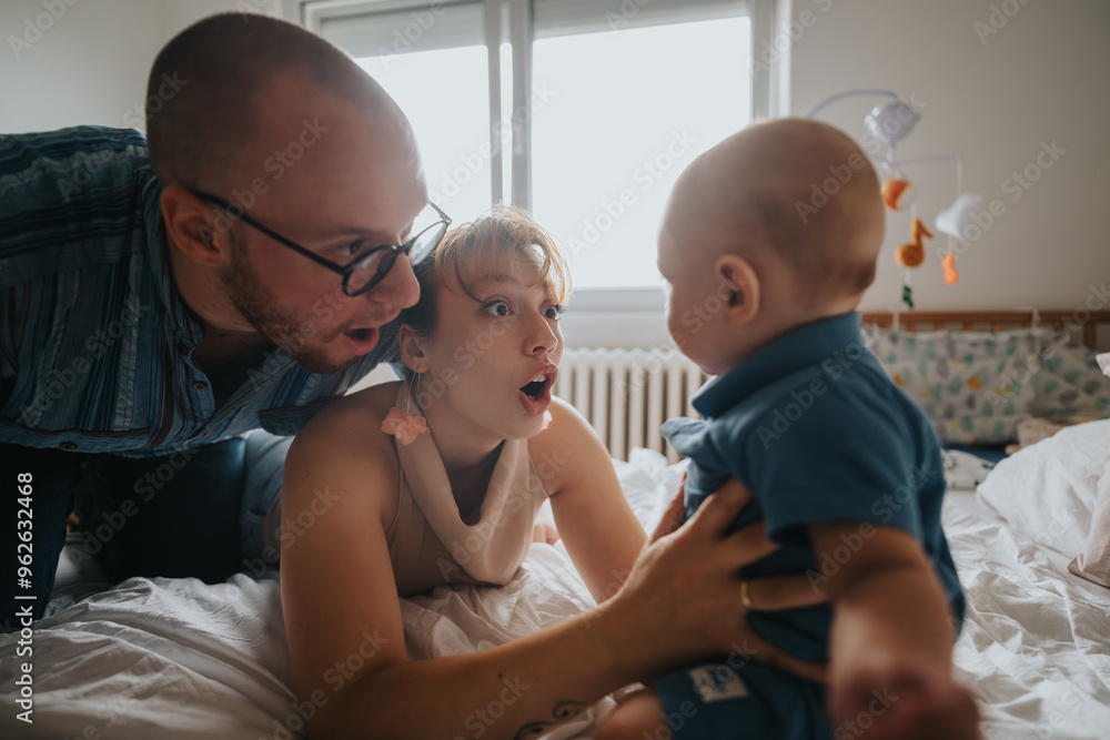 Adorable moment of surprised parents interacting with their baby in a warm bedroom atmosphere, showcasing family love and bonding. Adorable moment of surprised parents interacting with their baby in a warm bedroom atmosphere, showcasing family love and bonding.
