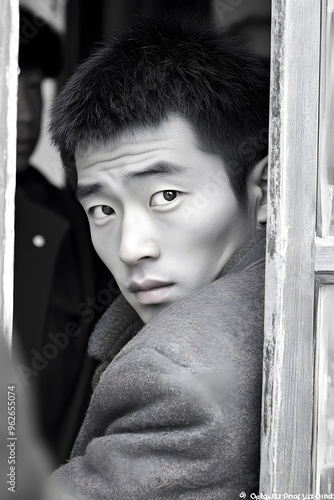 Young Man Looking Through Window in Black and White