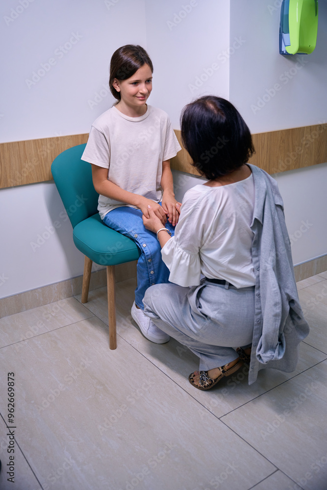 Woman with a teenage daughter in a hospital corridor Woman with a teenage daughter in a hospital corridor