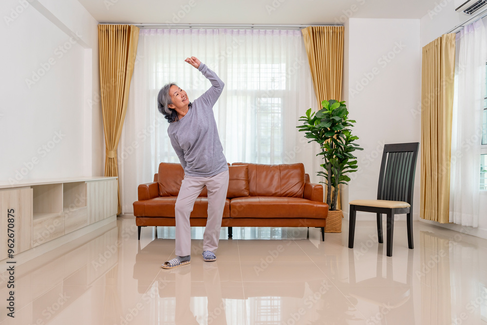 playful asian senior woman dancing in the living room,concept of elderly lifestyle,domestic life,relaxation,entertainment