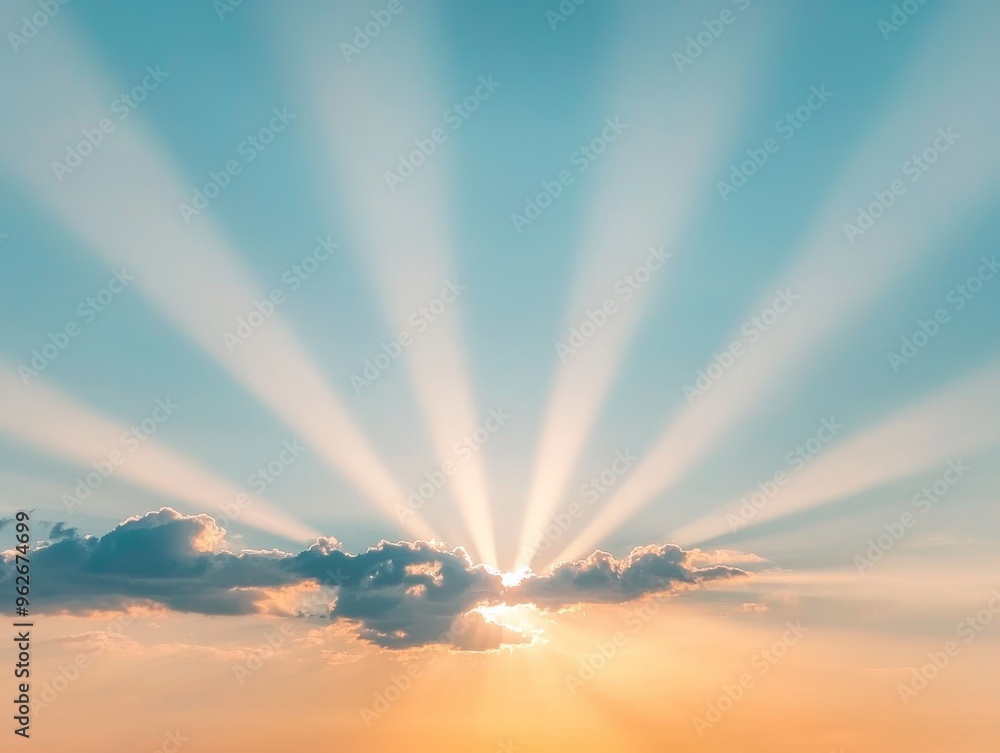 Fototapeta premium A stunning capture of radiant sunlight emerging from behind clouds, casting beautiful rays across a clear blue sky.