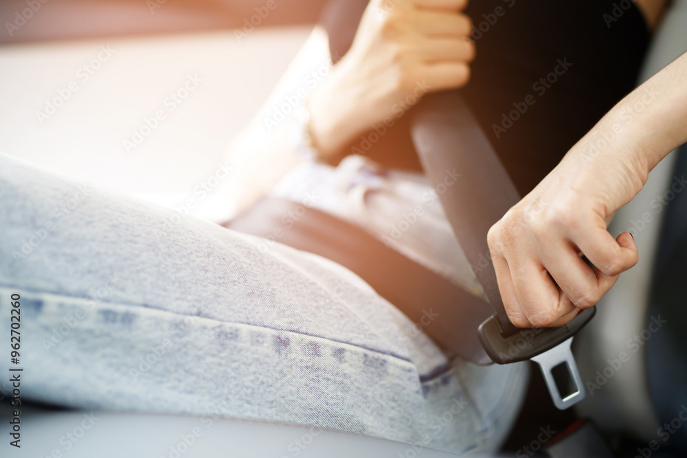 Close Up of people business woman hand fastening seat safety belt in car for safety before driving on the road. concept transport travel. soft focus. Close Up of people business woman hand fastening seat safety belt in car for safety before driving on the road. concept transport travel. soft focus.