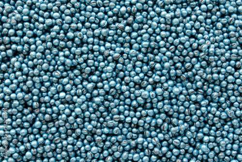 Treated rapeseed with blue coating, background, texture, top view. Encrusted rapeseed ready for sowing. Background of treated rapeseed, blue color, texture, top view.