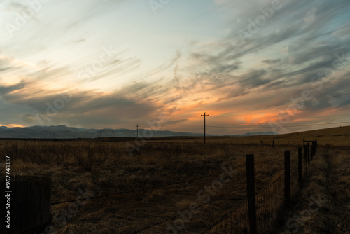 Rural landscape at sunset with power lines, dramatic skies,open fields