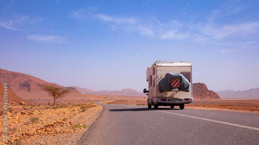 Obraz premium motorhome on asphalt road on arid landscape