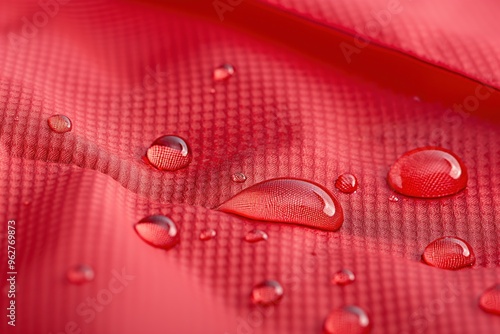 Red ripstop fabric water droplets beading up, water repellency in close-up studio shot. Copyspace allows for text branding insertion. High-resolution image suitable for product photography, synthetic photo