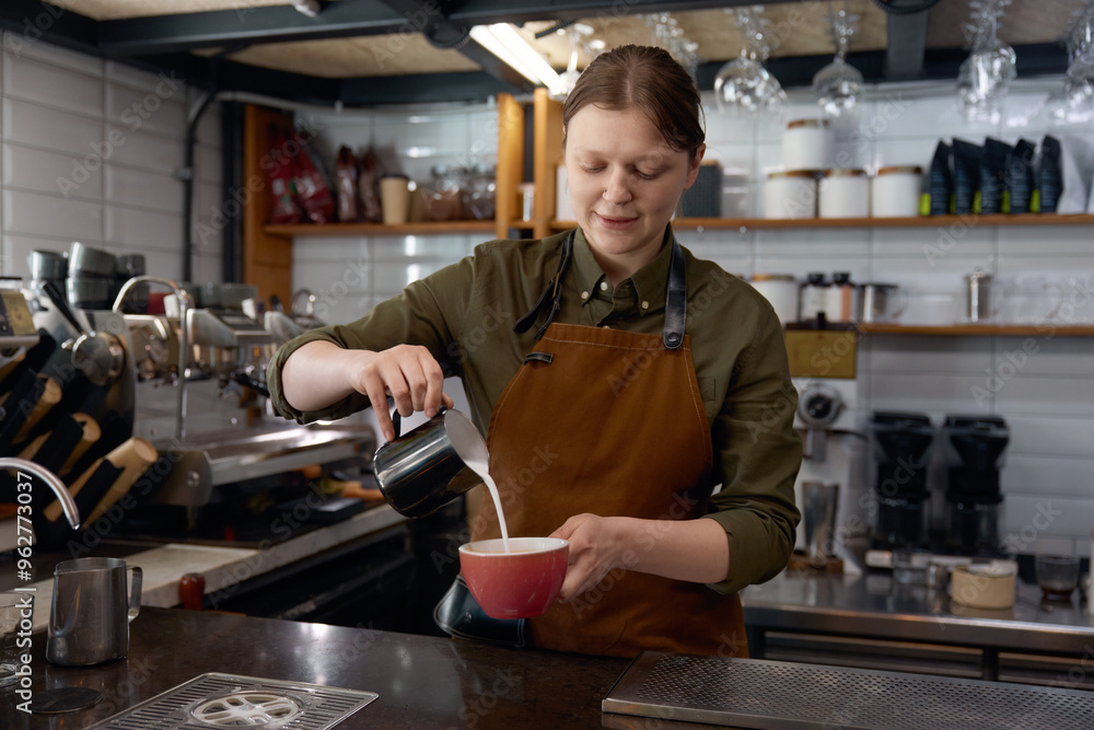 Barista hands pouring milk into coffee in cup Barista hands pouring milk into coffee in cup