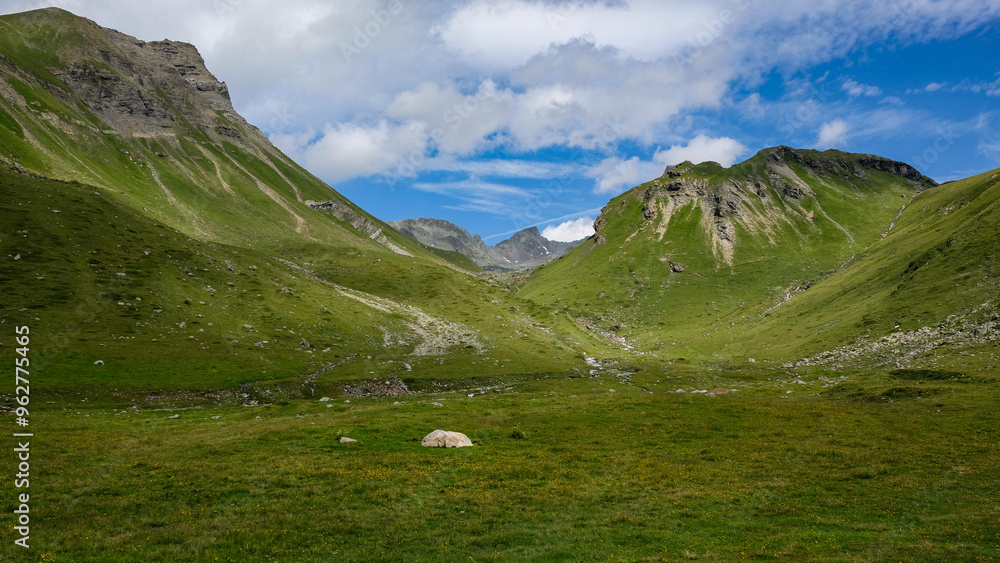 Scenic alpine view near Julier pass in Albula Alps with green pastures,  small mountain streams and mountain peaks in Grisons Switzerland