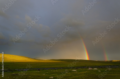 rainbow in the sky. Valley with shadow, beautiful sky with clouds and pare rainbow, two rainbow