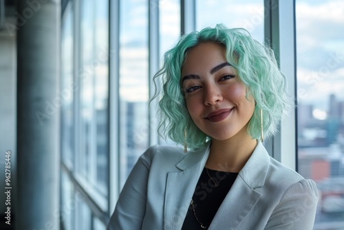 Portrait of happy, cofident lesbian businesswoman with green hair, in office with large windows  photo