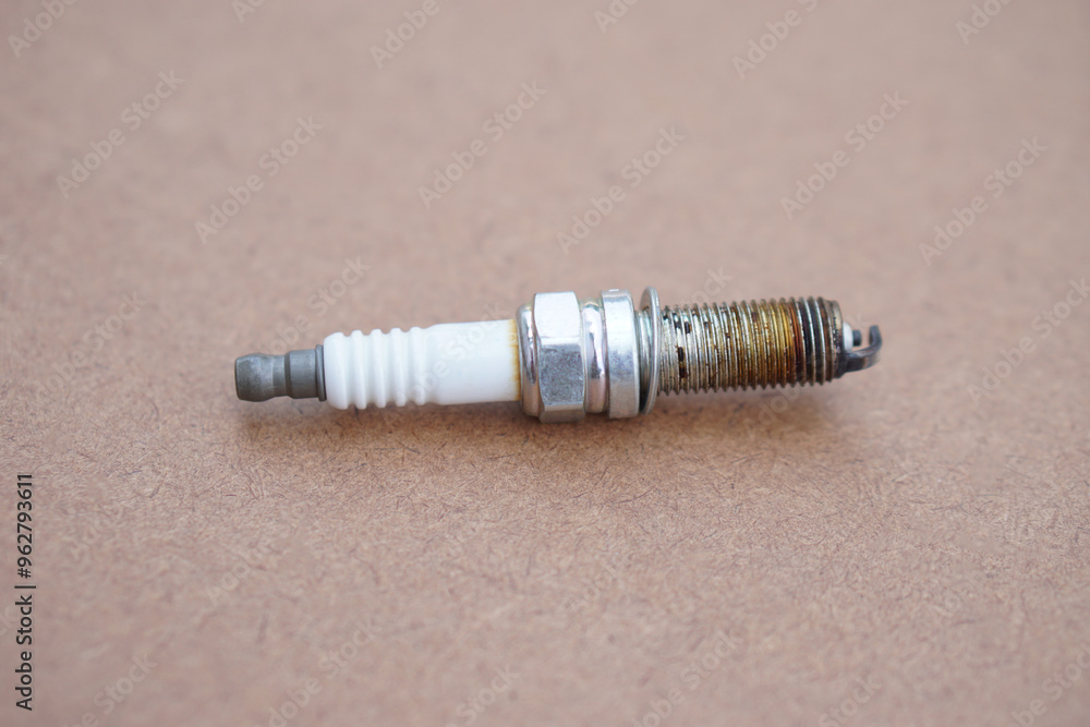 Spark plug on brown background. spare part of car engine. Concept, machine maintenance, fix, repair, check or diagnose automobile problems by engine specialist. Spark plug on brown background. spare part of car engine. Concept, machine maintenance, fix, repair, check or diagnose automobile problems by engine specialist.