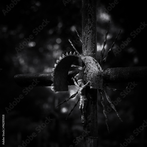 
CEMETERY - An old cross with a figurine of Jesus on a tombstone
 photo