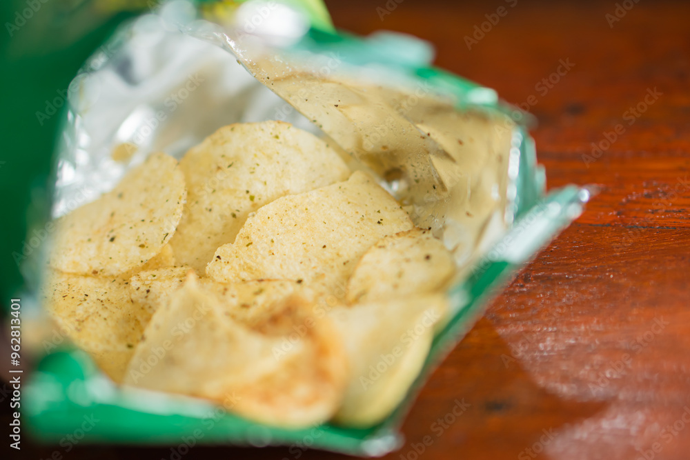 Open Bag of Potato Chips on Wooden Table Open Bag of Potato Chips on Wooden Table