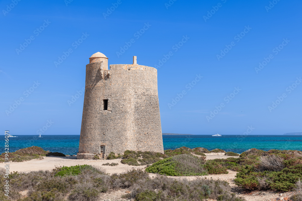 Torre de ses Portes, a historic watchtower on Ibiza, Spain, with yachts and boats in the Mediterranean Sea Torre de ses Portes, a historic watchtower on Ibiza, Spain, with yachts and boats in the Mediterranean Sea