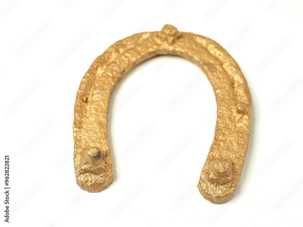A gold horseshoe is shown on a white background. The horseshoe is curved and has a shiny, metallic appearance. Concept of elegance and luxury, and investing in art and precious metals. A gold horseshoe is shown on a white background. The horseshoe is curved and has a shiny, metallic appearance. Concept of elegance and luxury, and investing in art and precious metals.