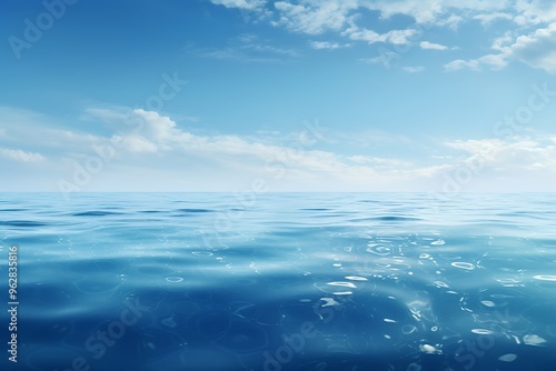 Underwater view of coral reef and blue sky with white clouds.