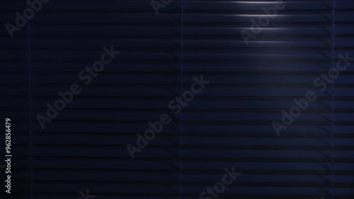in search of a criminal, a male thief with a flashlight illuminates the room through the blinds, close-up