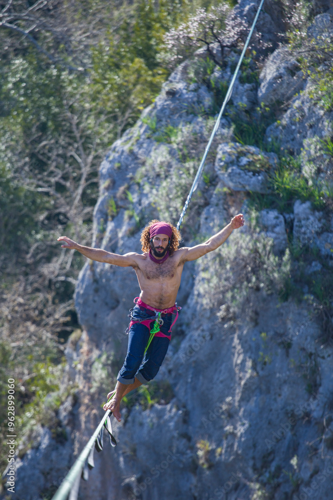 Fototapeta premium A tightrope walker walks along a cable stretched over a canyon.