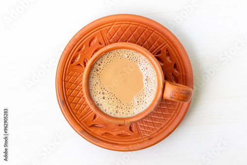 A cup of hot Milk tea or Dudh Cha in a traditional natural clay cup. Top view.