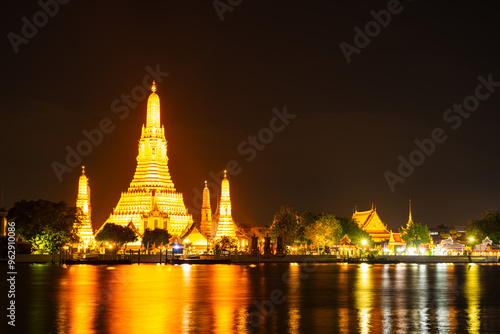 Beautiful Wat Arun Ratchawararam temple with reflexion in the river at twilight in Bangkok Thailand photo