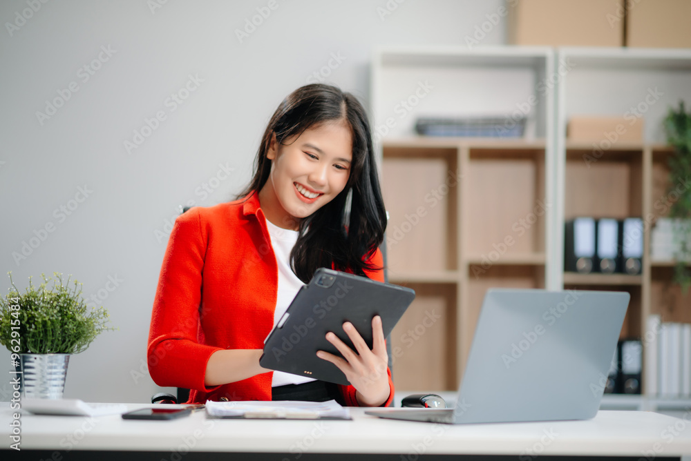 Young Asian businesswoman working at office with laptop, tablet and taking notes on the paper Young Asian businesswoman working at office with laptop, tablet and taking notes on the paper