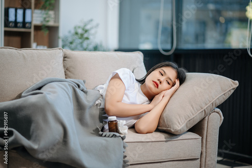 Asian woman sit Depression Dark haired pensive glance Standing by window and anxiety Copy space with a blanket on a sofa.